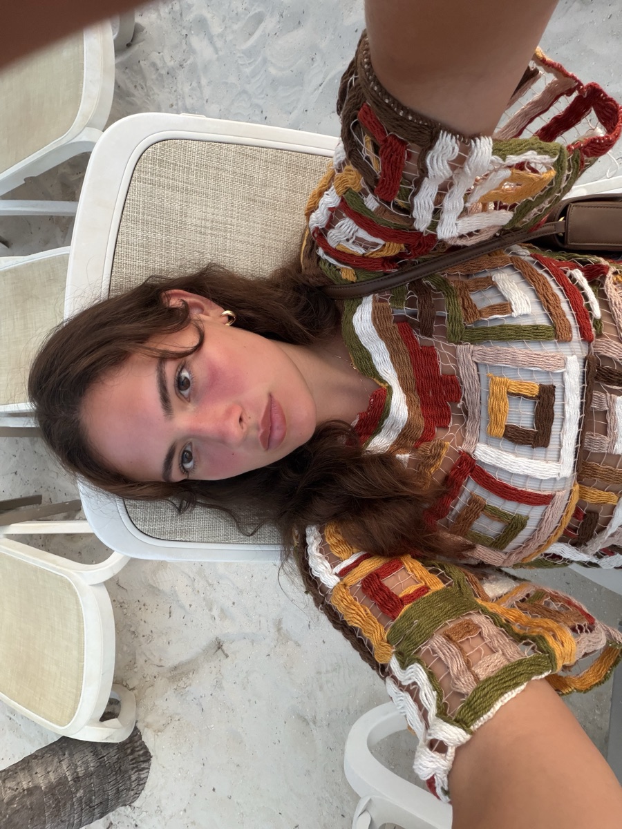 Flora on a beach chair in a colorful crochet top